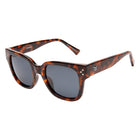 Sunglasses with tortoiseshell frame and dark lenses on a white background