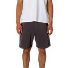 A model from the waist down wearing dark charcoal gray shorts and a white t-shirt, standing against a light gray background.