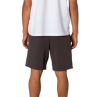 A person shown from the back wearing dark charcoal gray shorts and a white tank top against a light gray studio background.