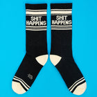 Black socks with 'SHIT HAPPENS' text on a blue background