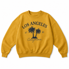 A mustard yellow crewneck sweatshirt with a dark navy graphic on the front featuring the text 'LOS ANGELES', 'California', the year '1781', and two palm trees.