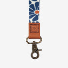 Lanyard with floral pattern and brown leather clip on a white background
