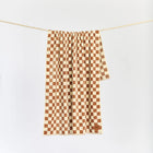 Checkered towel hanging on a line against a white background