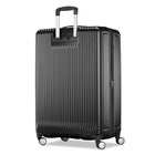 A black hard-shell spinner suitcase with vertical ribbing, an extended telescopic handle, and four multi-directional wheels, shown on a plain white background.
