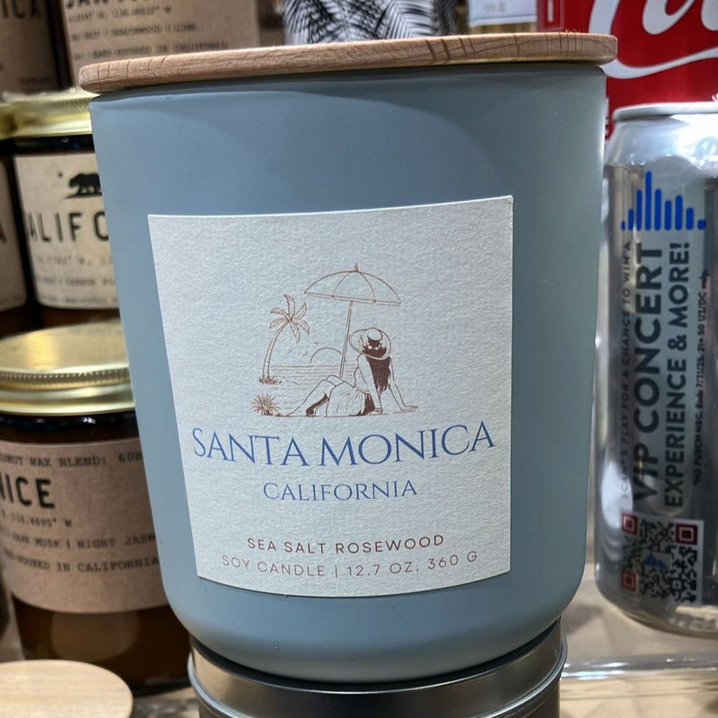 Blue candle labeled 'Santa Monica, California' with a Coca-Cola can in the background.