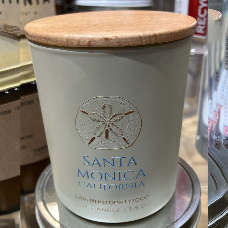 Candle with wooden lid labeled 'Santa Monica, California' in a store setting
