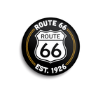 Round black badge with Route 66 logo and text on a white background