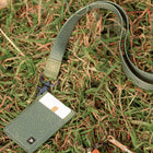 Green cardholder with strap on grass