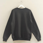 Black sweatshirt on a hanger against a beige wall