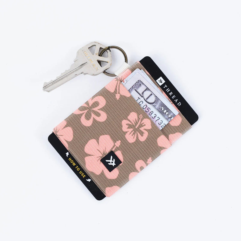 Floral patterned keychain with a card holder and key attached on a white background
