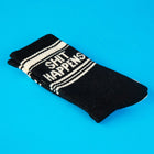 Black sock with 'SHIT HAPPENS' text on a blue background
