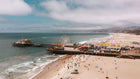 Beach scene with pier, Ferris wheel, and ocean waves