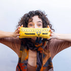 Person holding a yellow ruler with a smiley face and 'Teachers Rule' text against a white background