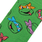 Green sock with cartoon character faces on a white background