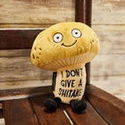 Plush mushroom toy with humorous text on a wooden bench