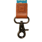 Close-up of a strap with a brown leather buckle and blue fabric background