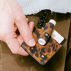 Leopard print cardholder with vape device and card on a brown background