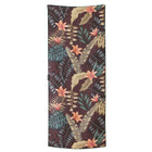 Towel with tropical leaf and flower pattern on a brown background