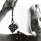 Black and white polka dot keychain held by a person with a woman wearing a matching outfit.