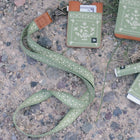 Green patterned dog leash and matching keychain with card holder on a textured surface