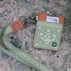 Green patterned wallet with strap on a textured surface