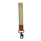 Green strap with floral pattern and brown leather end on a white background