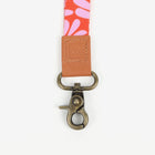 Floral lanyard with a brown leather patch and metal clasp on a white background