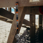 Thread Neck Lanyard - Sanders with a card holder attached to a metal structure on a beach.