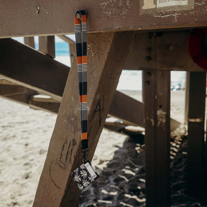 Thread Neck Lanyard - Sanders with a card holder attached to a metal structure on a beach.