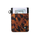 A slim card holder wallet with a brown and black leopard print pattern, featuring a black metal key ring on the left and a white card and dollar bill tucked into the top slot. A small white stylized logo is visible near the bottom right corner.