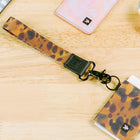 Leopard print lanyard with a key holder on a wooden surface